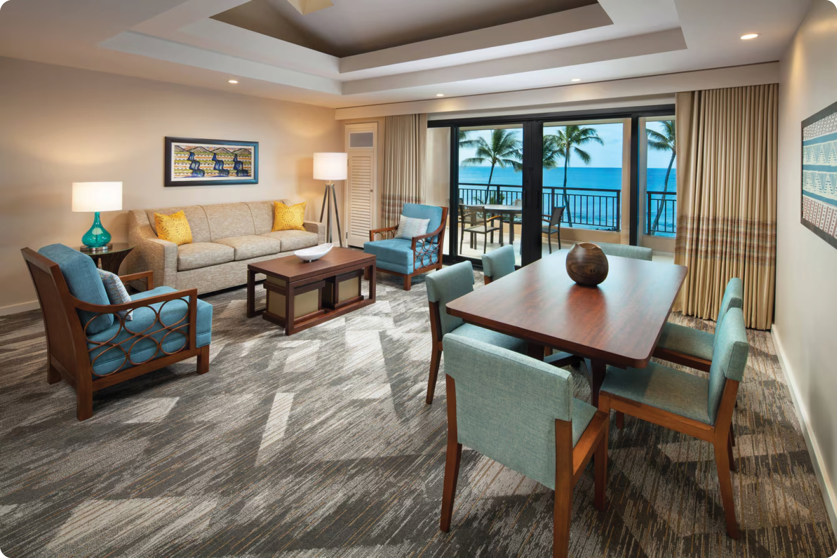 A living room with a table and chairs, a couch, and a lamp. The table is set for a meal, and there is a view of the ocean through the sliding glass doors. AI generated content