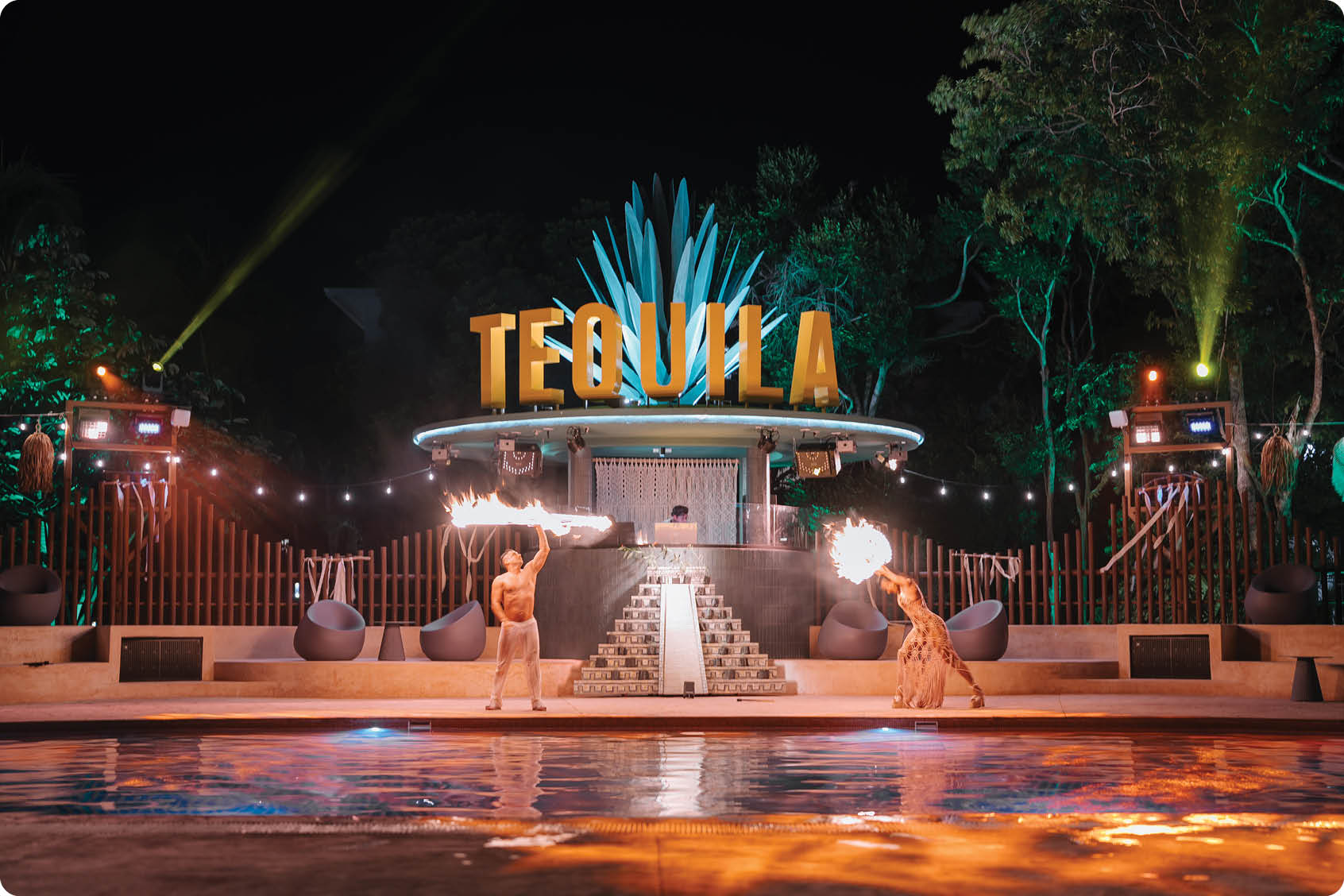 A group of people are performing in front of a sign that says “Tequila." They are standing in a pool of water, and there are fireworks in the background. AI generated content