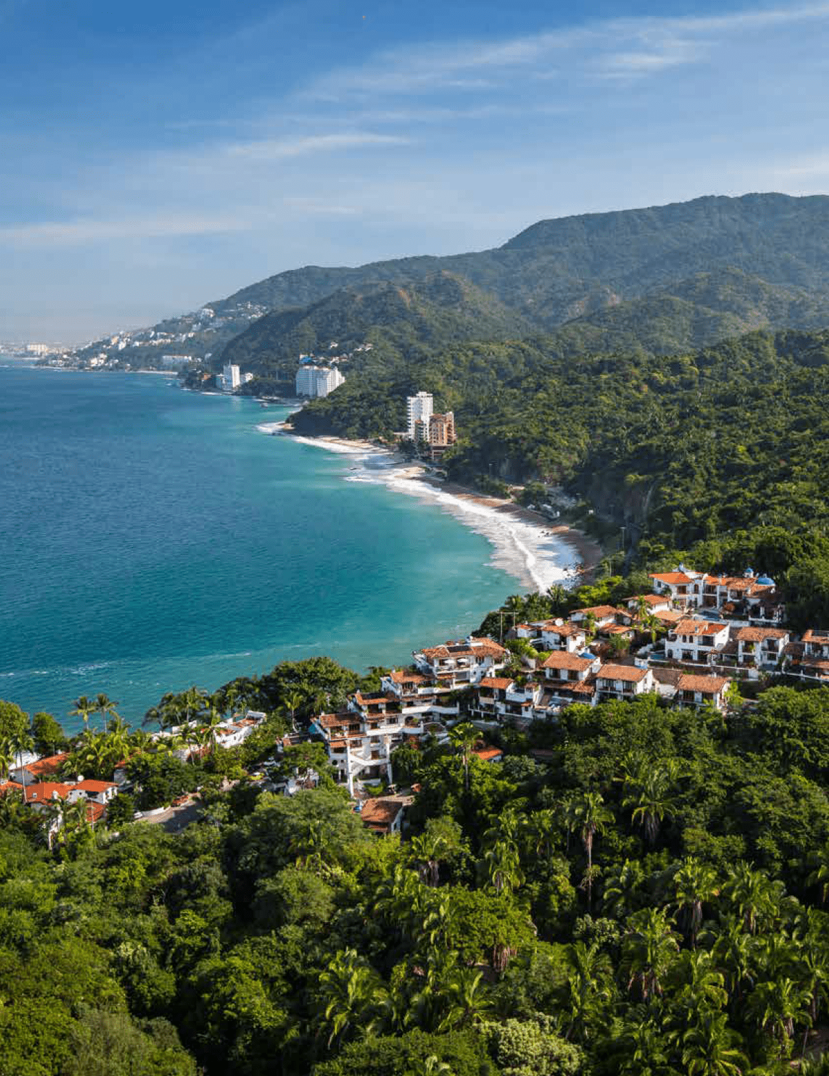 A coastal landscape with turquoise water, a sandy beach, lush green hills, and a cluster of white and terracotta-roofed buildings nestled among dense vegetation. Description generated by AI
